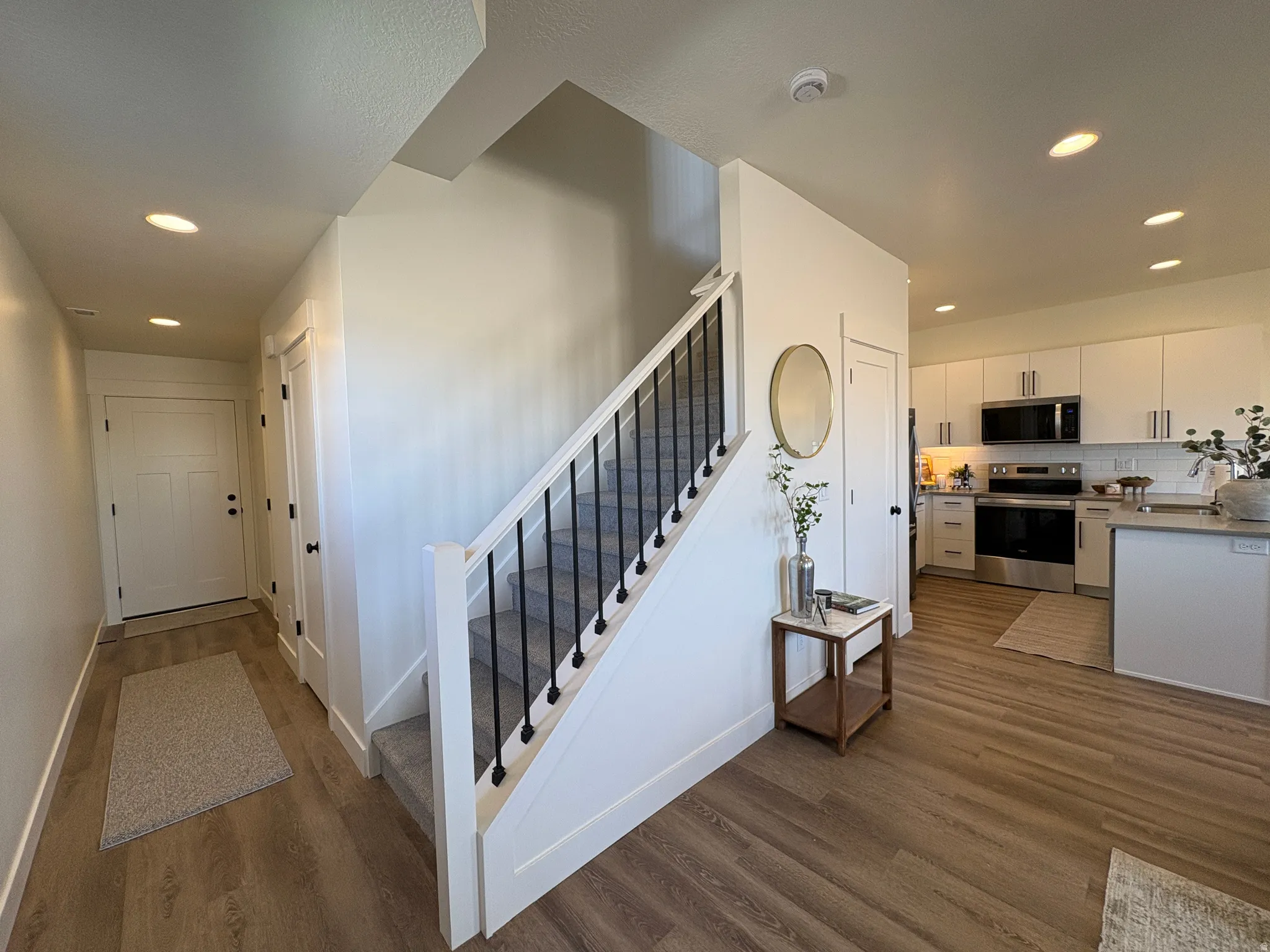 Stairway with recessed lighting and wood finished floors