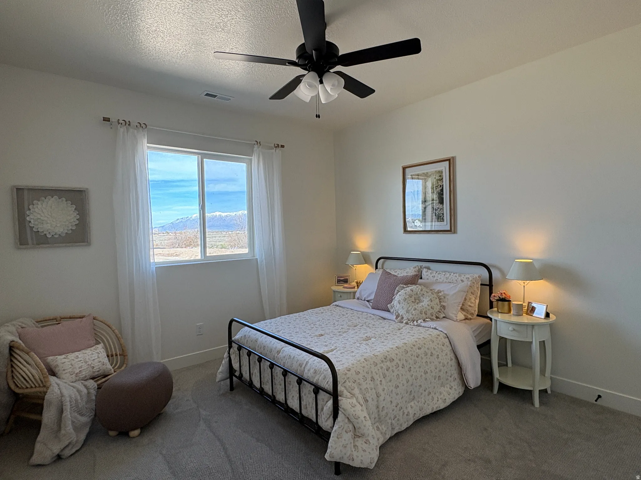 Carpeted bedroom with a ceiling fan and a textured ceiling