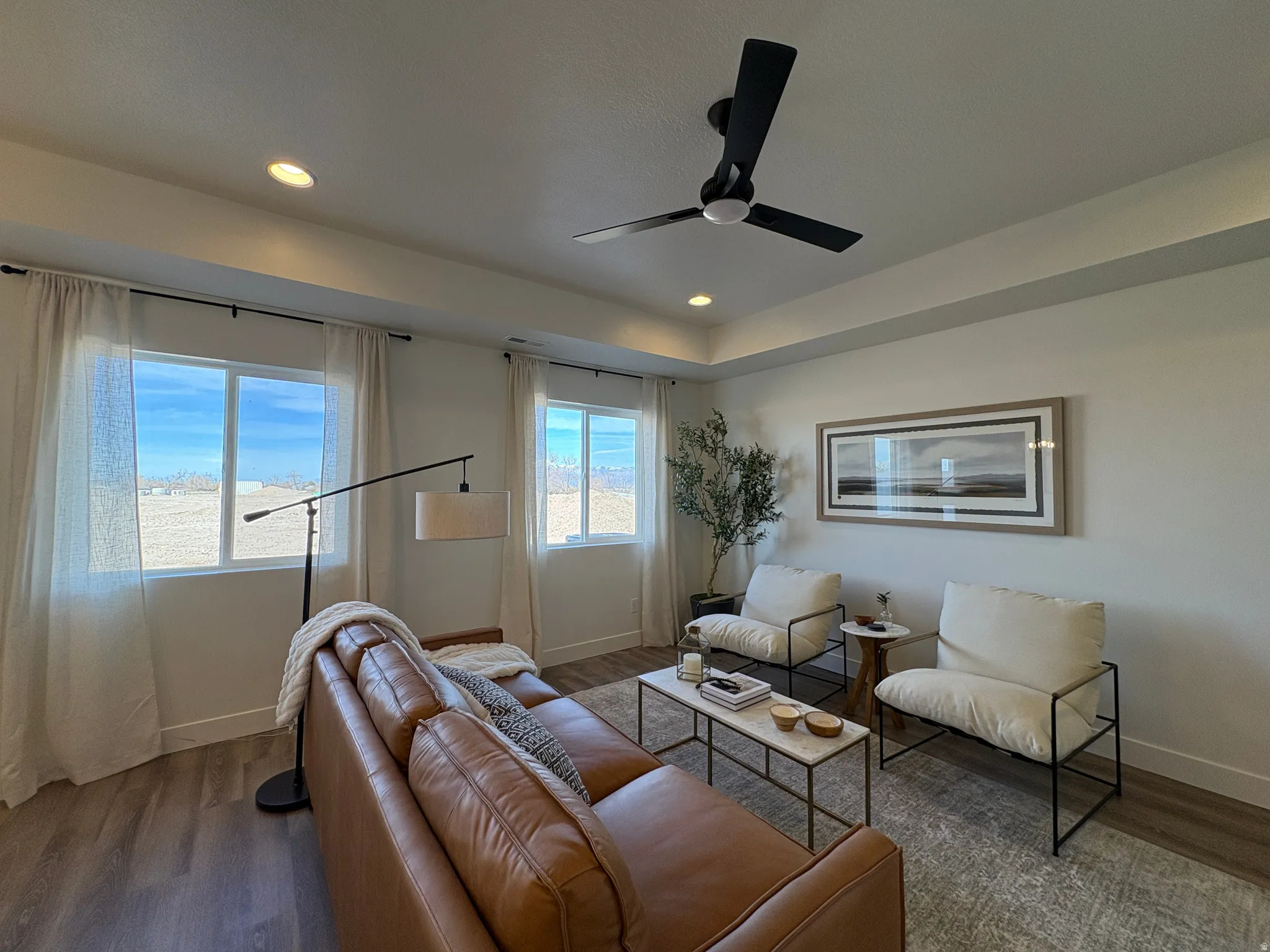 Living room with dark wood-style flooring, ceiling fan, and recessed lighting