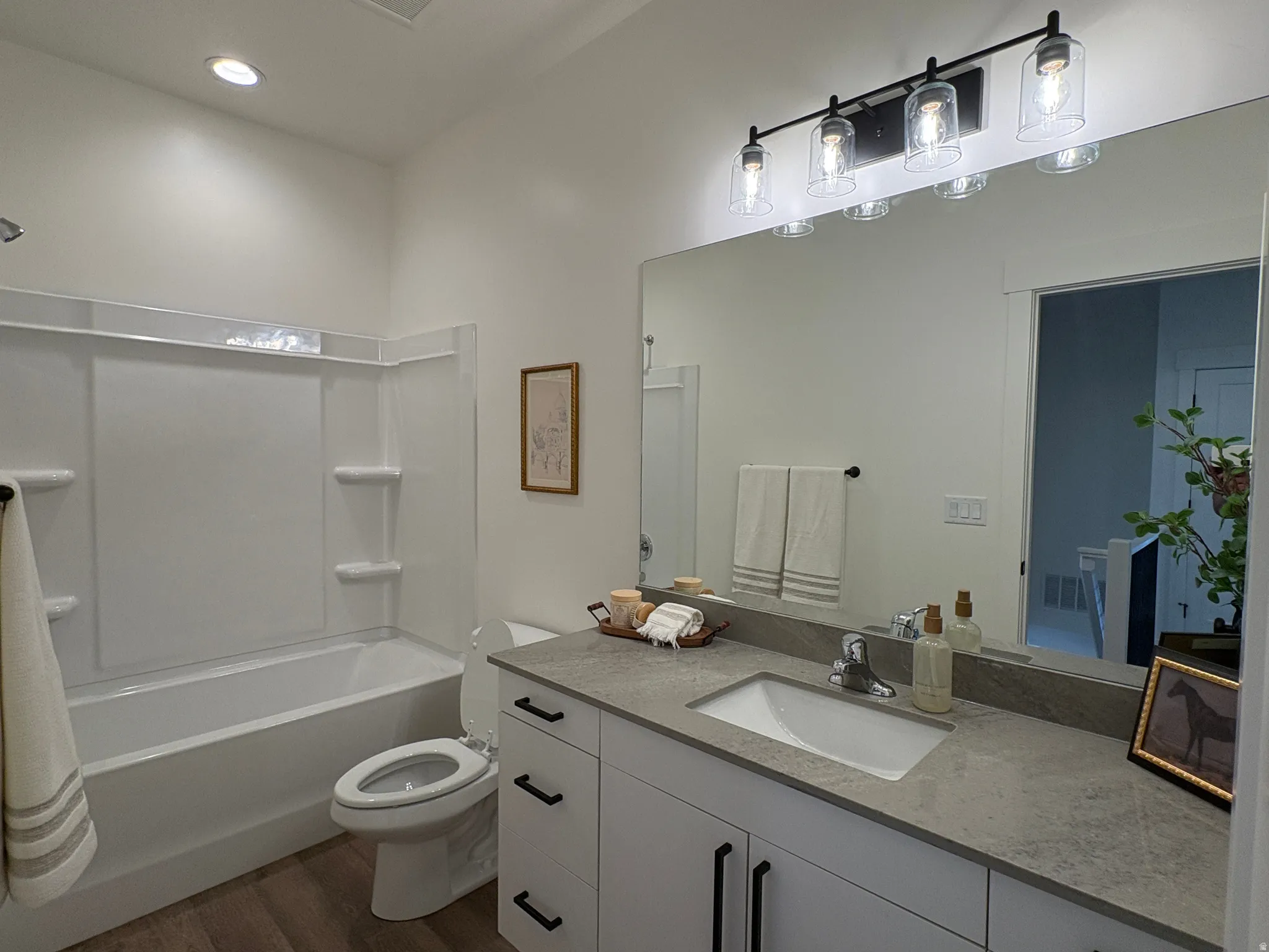 Full bathroom with vanity, dark wood finished floors, shower / tub combination, and recessed lighting