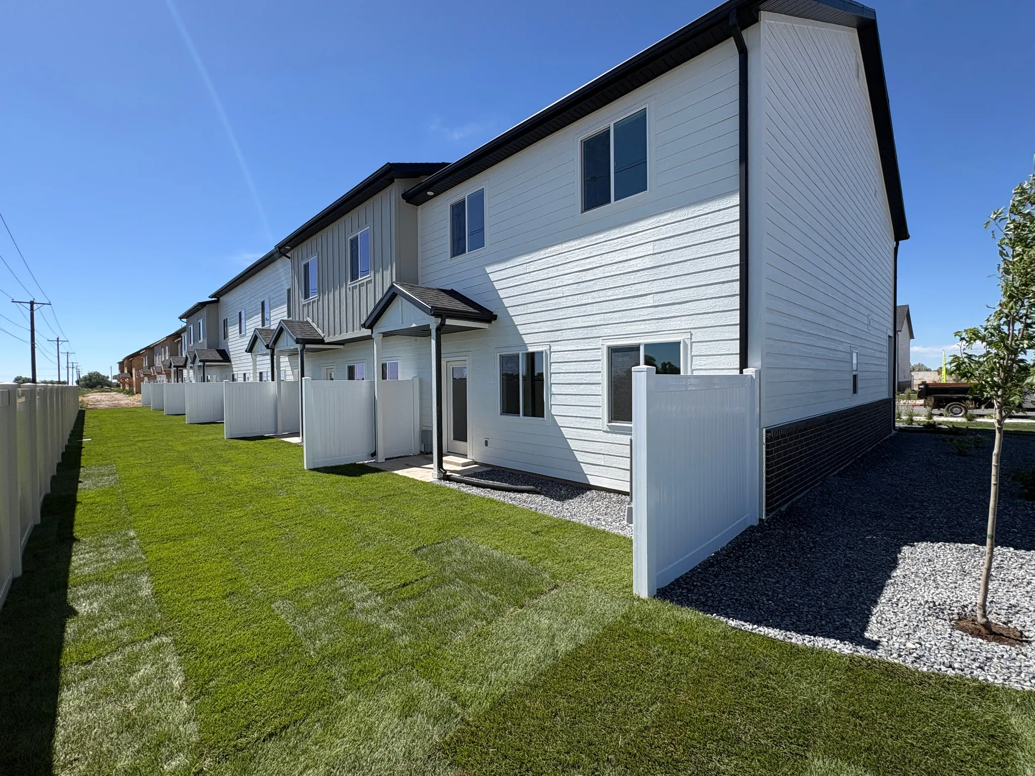 Contemporary townhome exterior featuring light-colored siding with dark trim accents