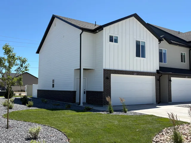 Modern townhome exterior featuring white horizontal siding and vertical paneling