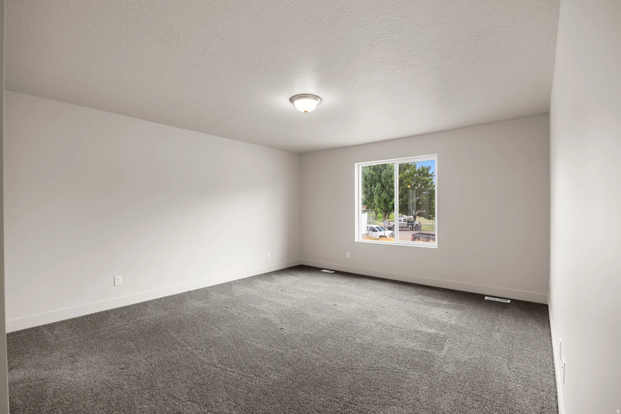 Empty room featuring carpet flooring and a textured ceiling