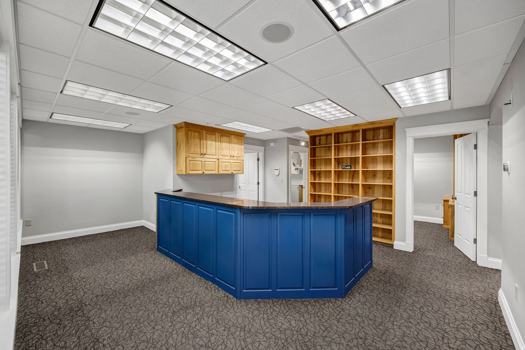 Reception area featuring dark colored carpet and a drop ceiling