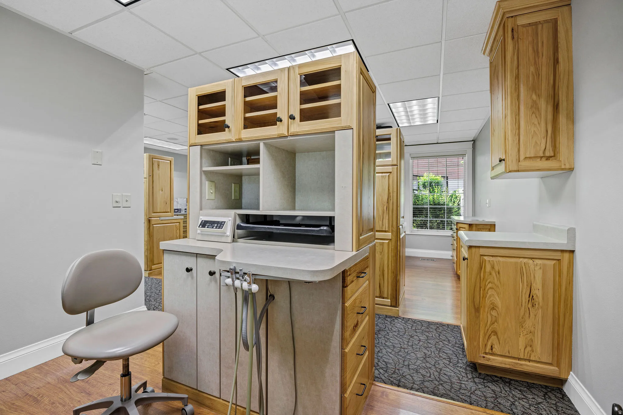 Procedure room with a paneled ceiling and oak cabinetry