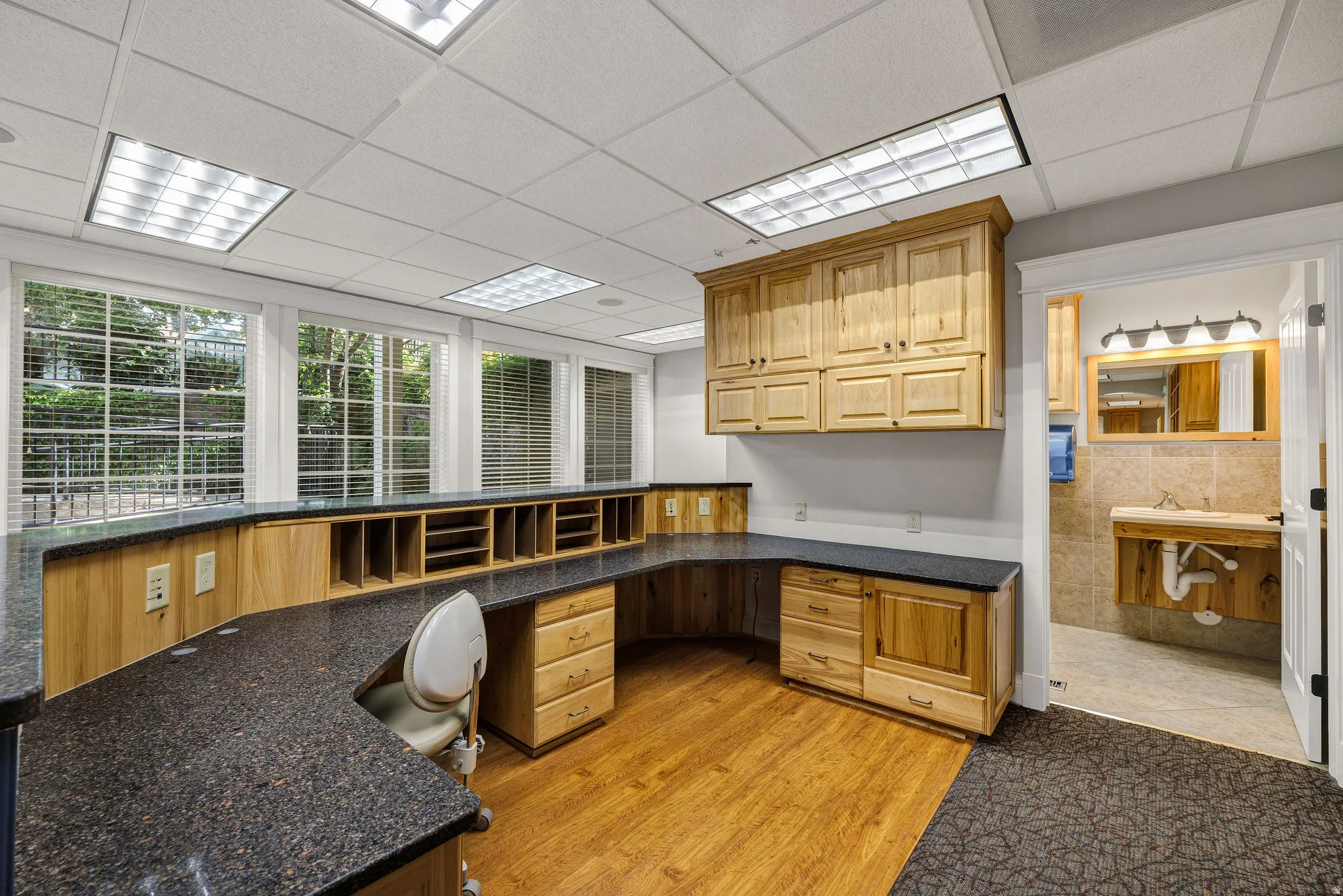 Reception area featuring light wood-style floors, a paneled ceiling, and built in reception desk