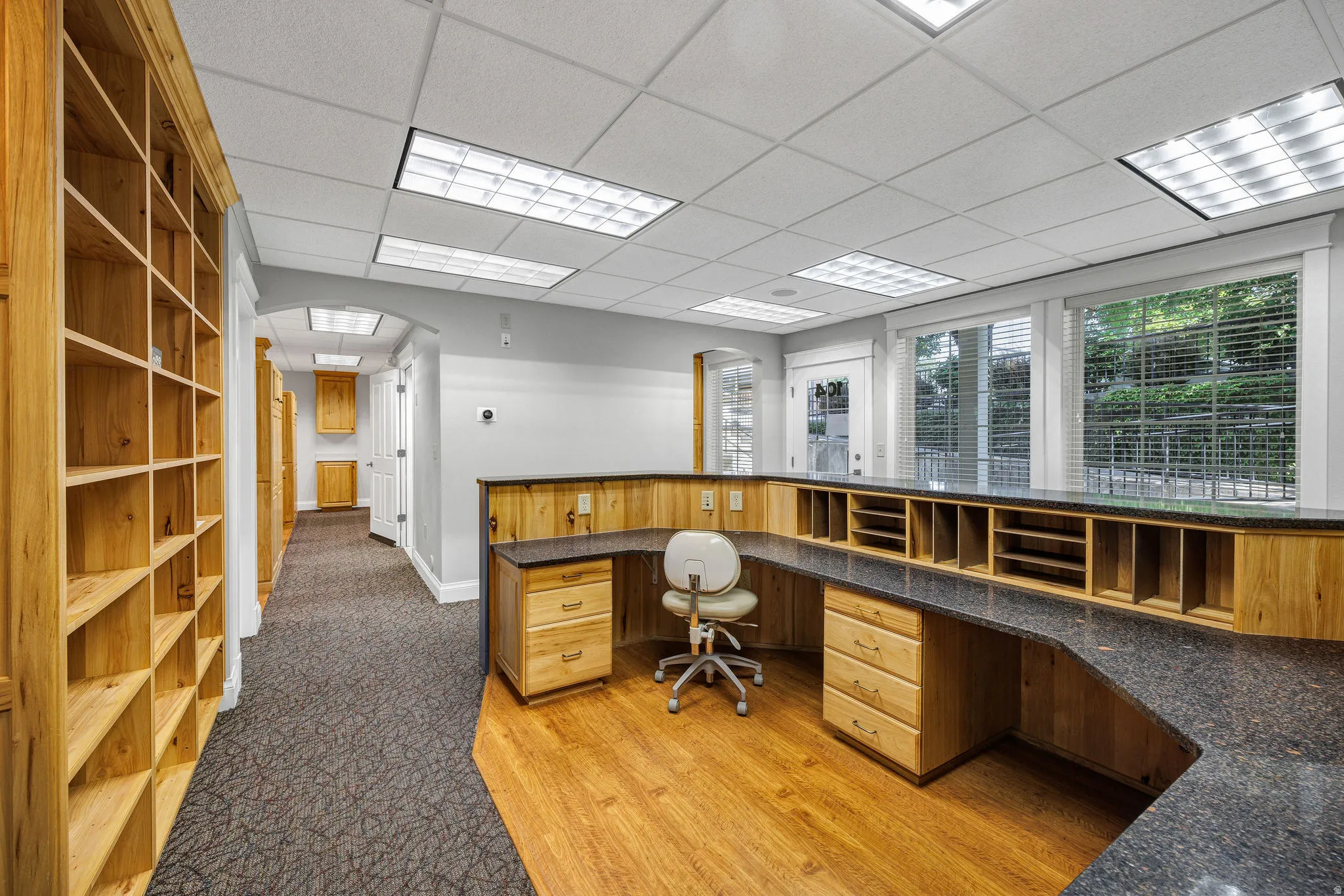 Reception area featuring built in desk, a paneled ceiling, and light wood finished floors