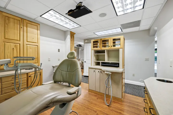 Procedure room with light wood-style floors and a drop ceiling and oak cabinetry