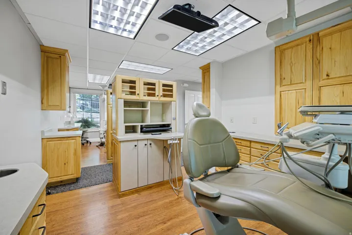 Procedure room featuring a drop ceiling, wood style floors and oak cabinetry.