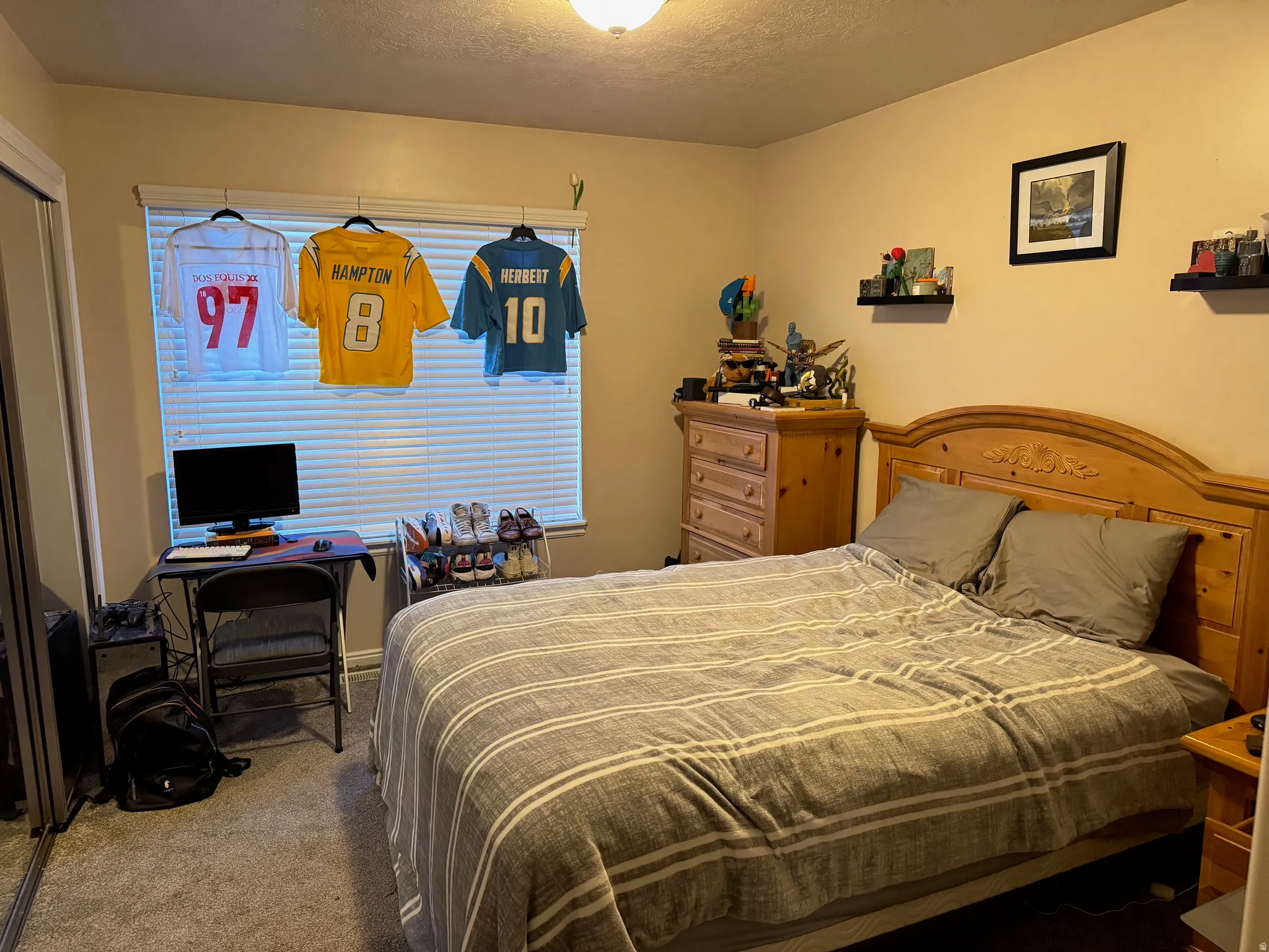 Bedroom with carpet flooring, an office area, and a textured ceiling