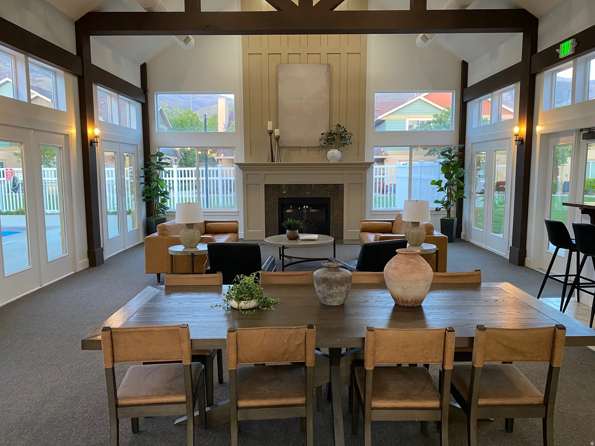 Carpeted dining space featuring vaulted ceiling, french doors, and a glass covered fireplace