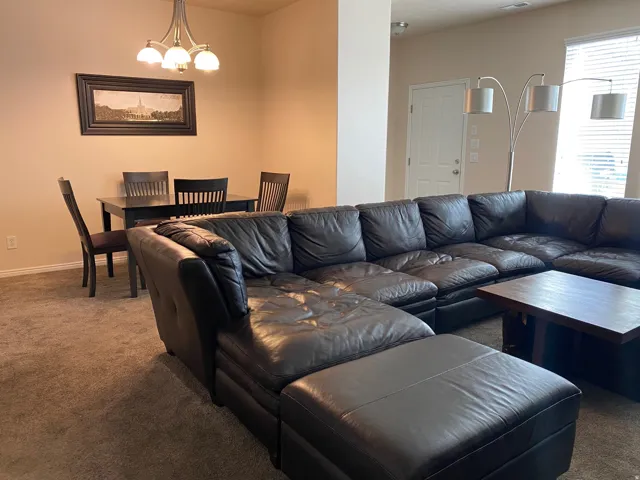 Carpeted living room featuring suspended lighting