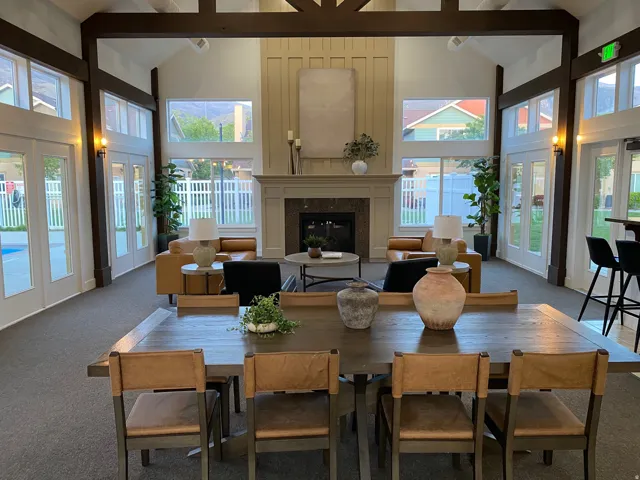Carpeted dining space featuring vaulted ceiling, french doors, and a glass covered fireplace