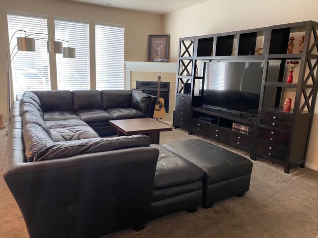 Living room with light colored carpet and a fireplace