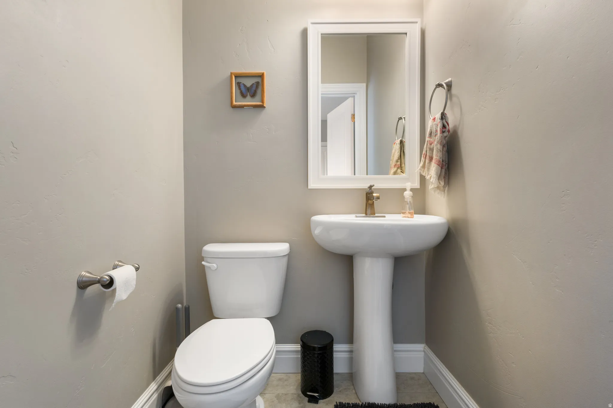 Half bath with toilet and light tile patterned flooring