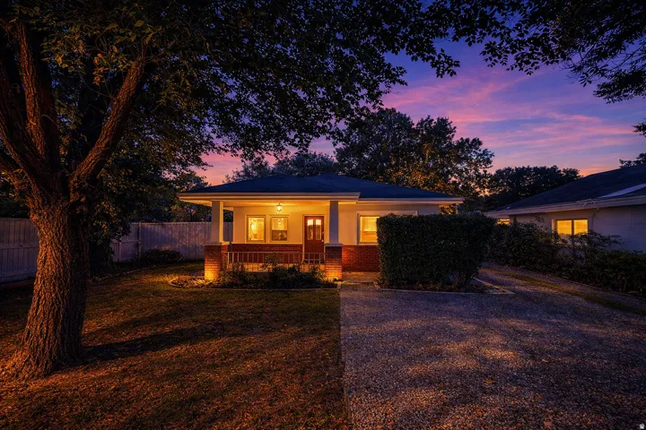 Bungalow with a porch and brick siding