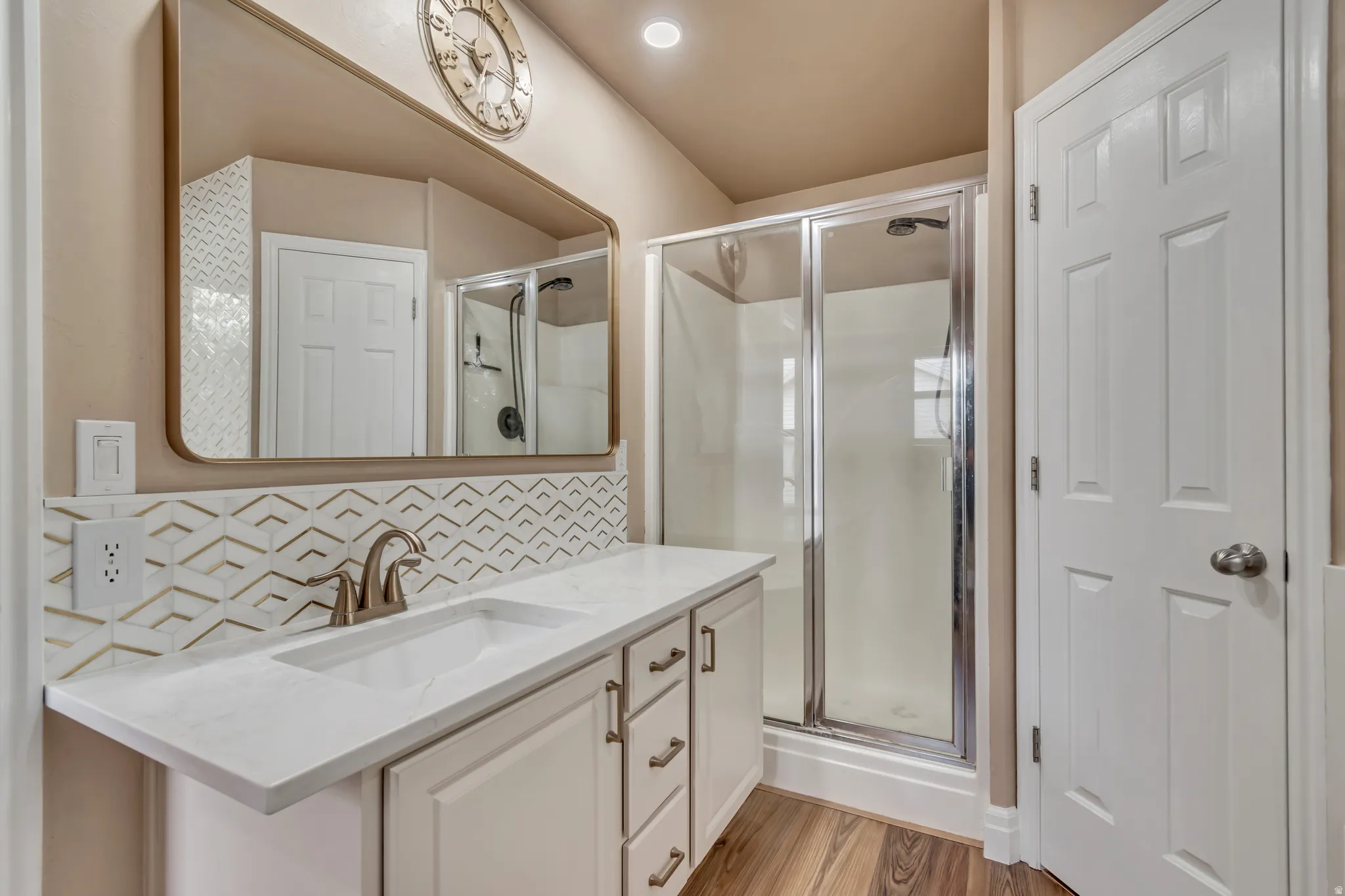 Full view of master bathroom vanity, a shower stall and custom backsplash.