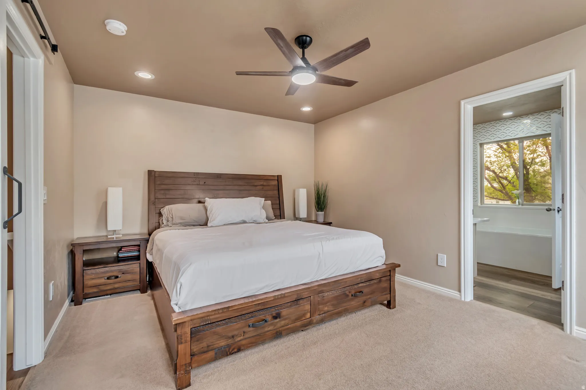Master bedroom featuring light Karastan premier carpeting, a ceiling fan, recessed lighting and an ensuite bathroom.