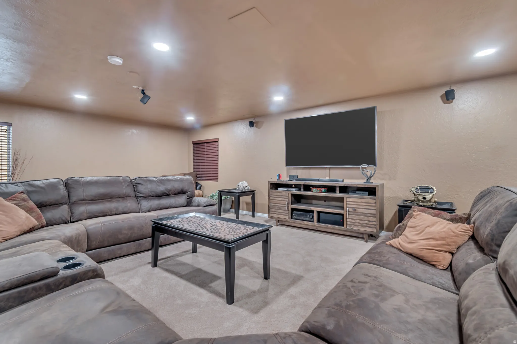 Wide-open downstairs living room with premium Karastan carpeting , textured walls, and recessed lighting.