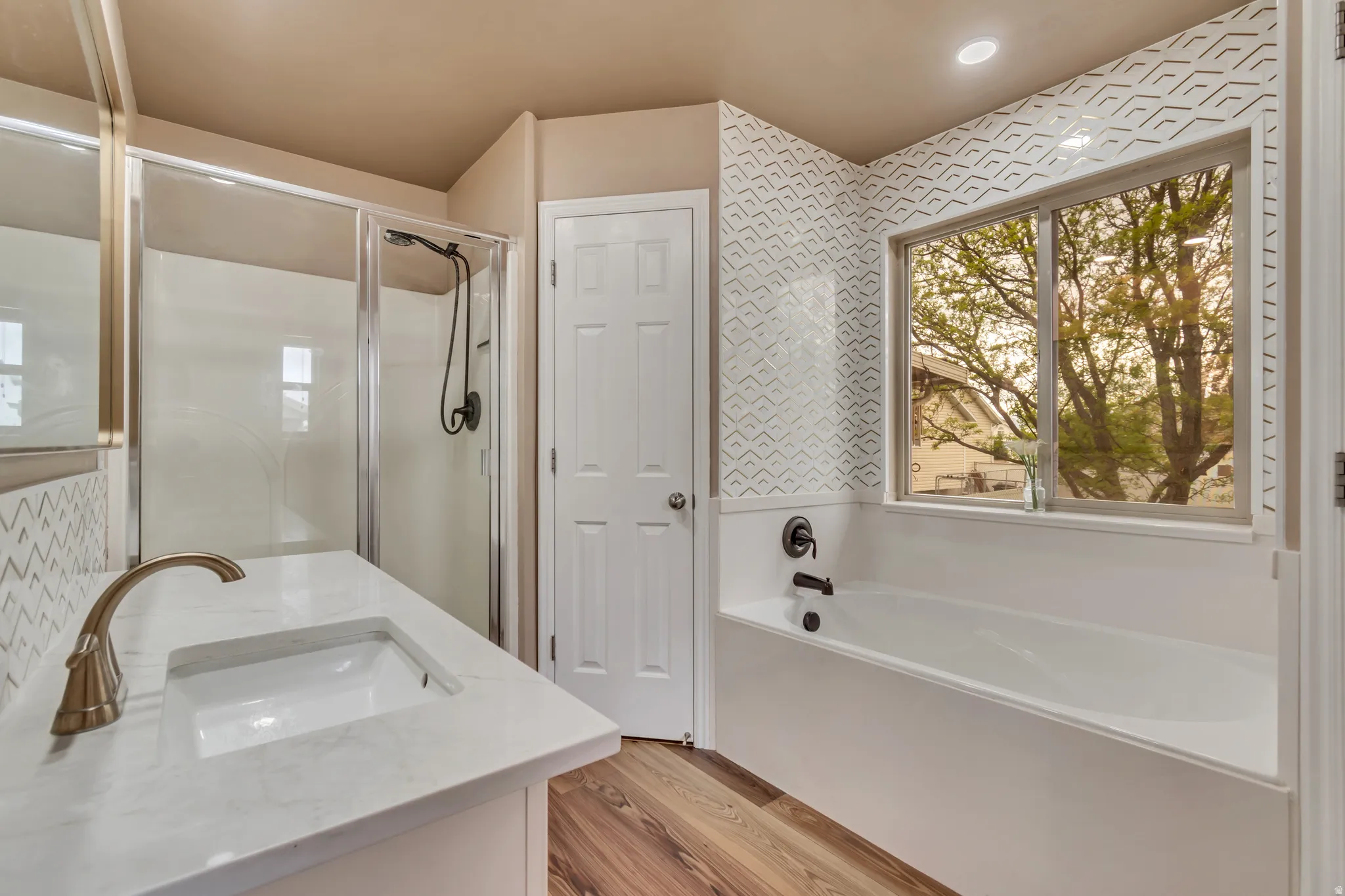 Completely updated master bathroom with vanity, a garden tub and a  stall shower.