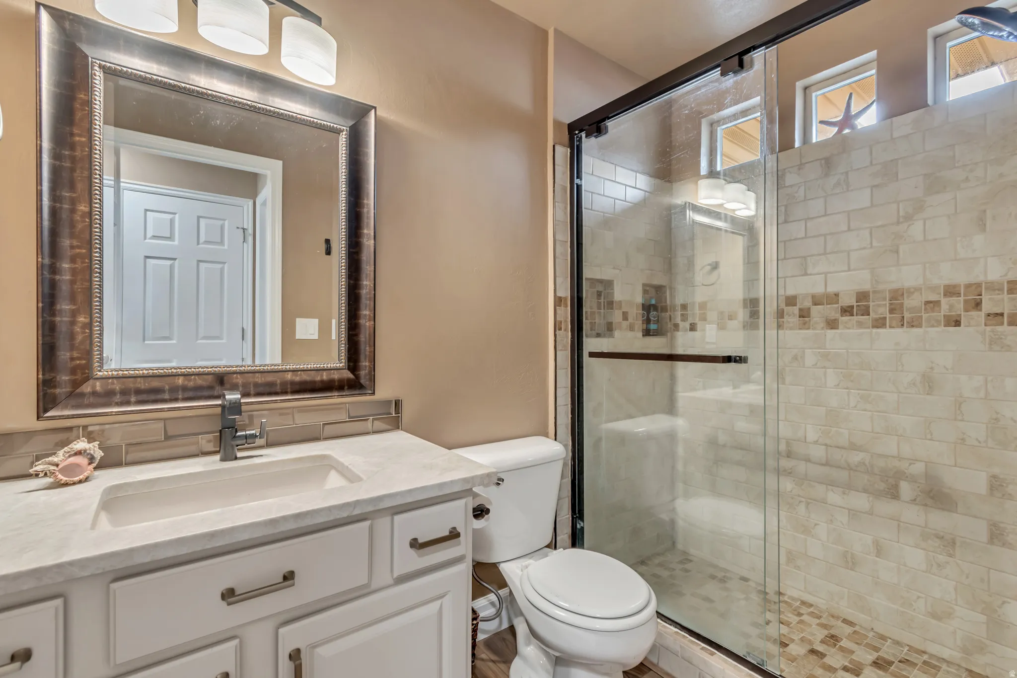 Updated guest bathroom featuring vanity and a stall shower.