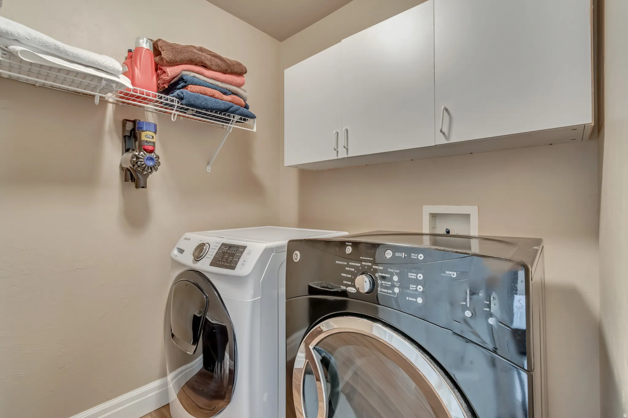 Laundry room featuring independent washer and dryer with plenty of cabinet space and coated shelving.