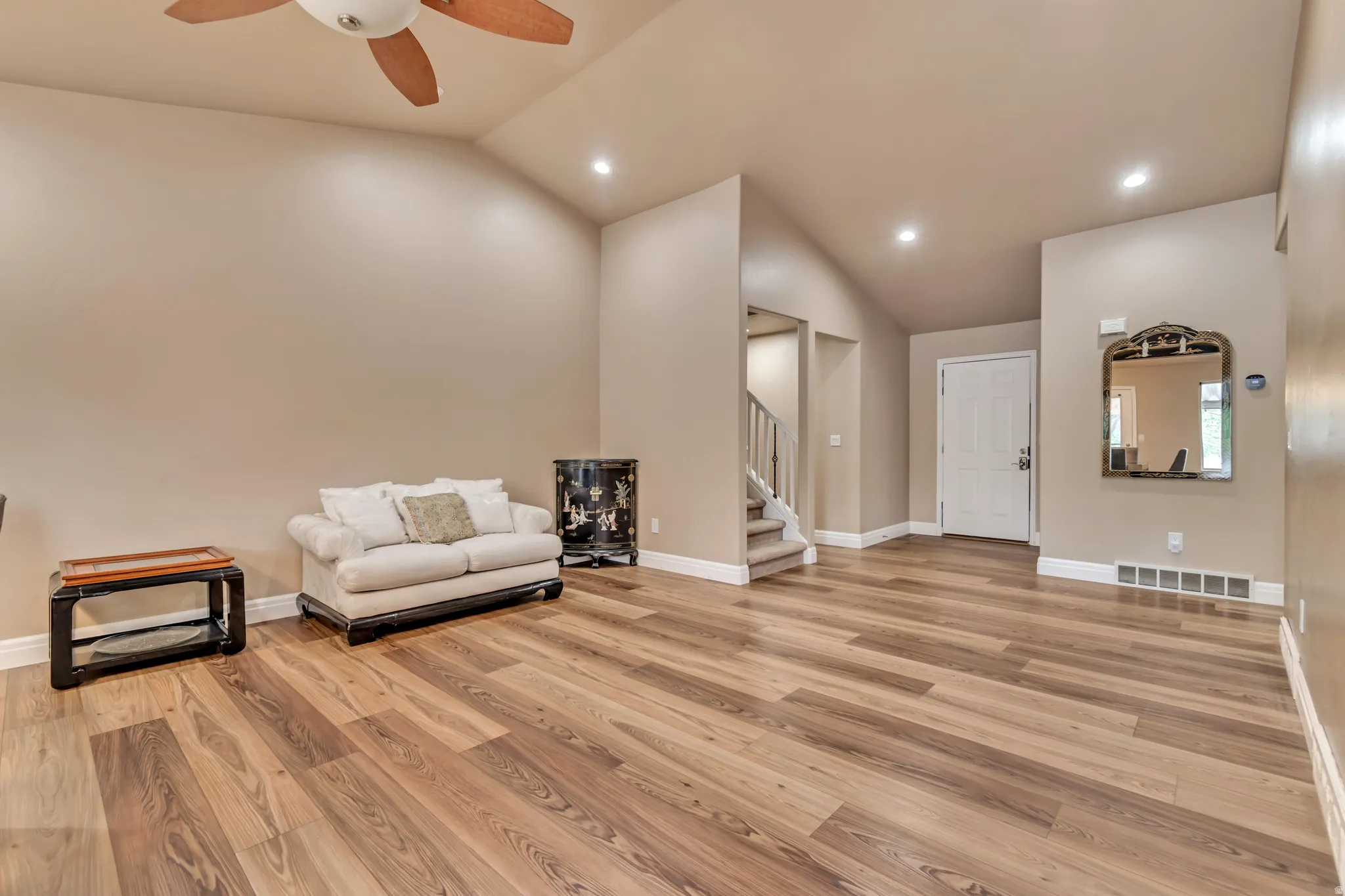 Wide-open living area featuring quality LVP floors, vaulted ceiling, recessed lighting and ceiling fan.