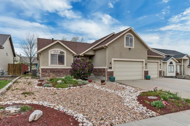 Ranch-style home featuring brick siding, stucco siding, 3-car garage, ample parking and a beautifully xeriscaped front yard.