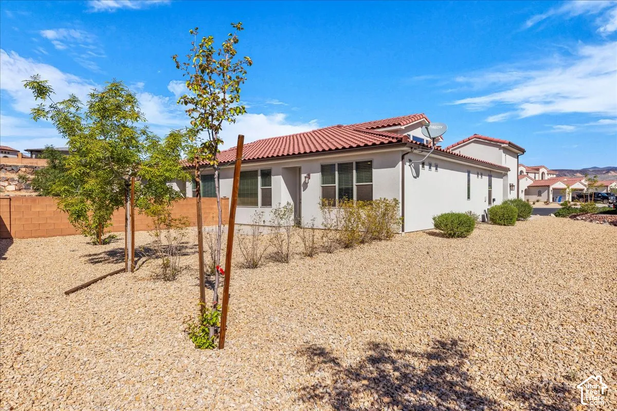 Back of property featuring stucco siding and a tile roof