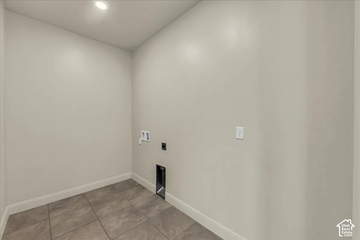 Laundry room with washer hookup, electric dryer hookup, light tile patterned floors, and recessed lighting