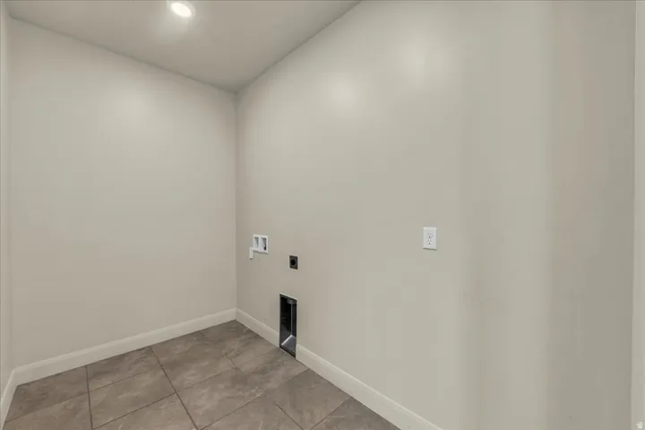Laundry room with washer hookup, electric dryer hookup, light tile patterned floors, and recessed lighting