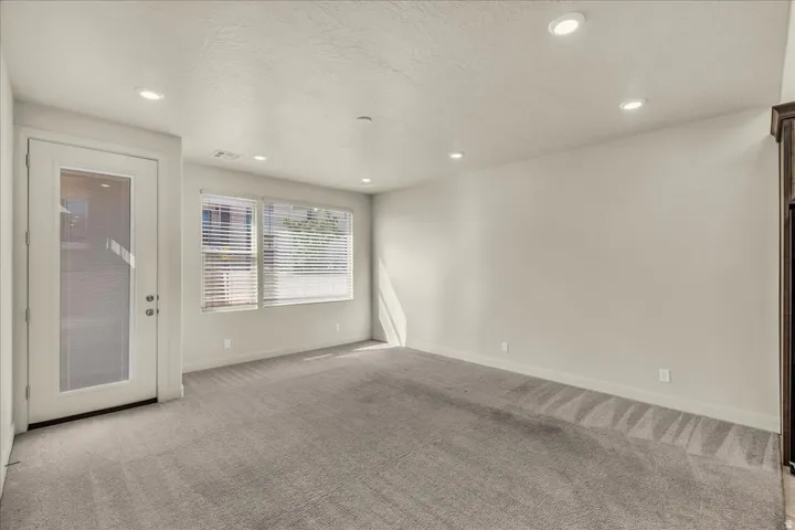Spare room featuring light carpet, a textured ceiling, and recessed lighting