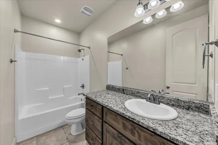 Full bathroom with vanity, bathtub / shower combination, light tile patterned floors, and recessed lighting