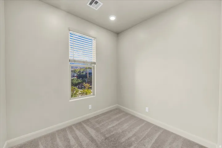 Spare room featuring light colored carpet and recessed lighting