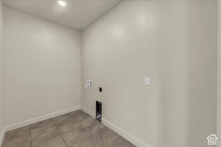 Laundry room with washer hookup, electric dryer hookup, light tile patterned floors, and recessed lighting