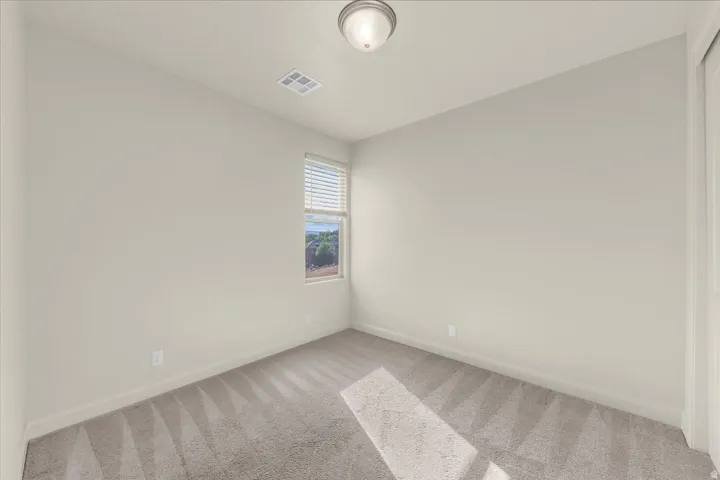 Spare room with baseboards and light carpet