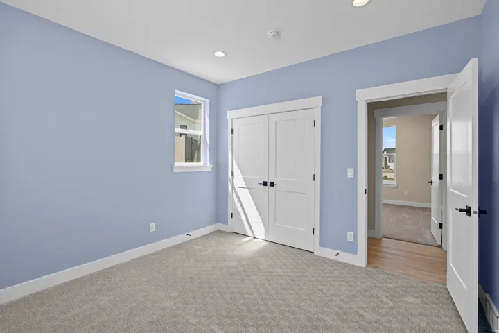 Unfurnished bedroom with light colored carpet and a closet