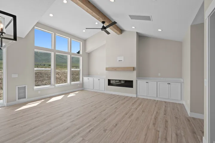 Unfurnished living room featuring light wood-type flooring, a glass covered fireplace, ceiling fan, and recessed lighting