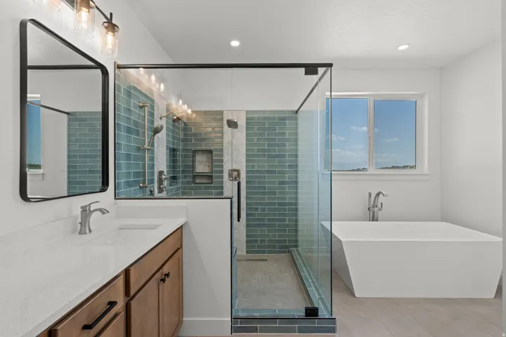 Full bath with a shower stall, a freestanding tub, vanity, and recessed lighting