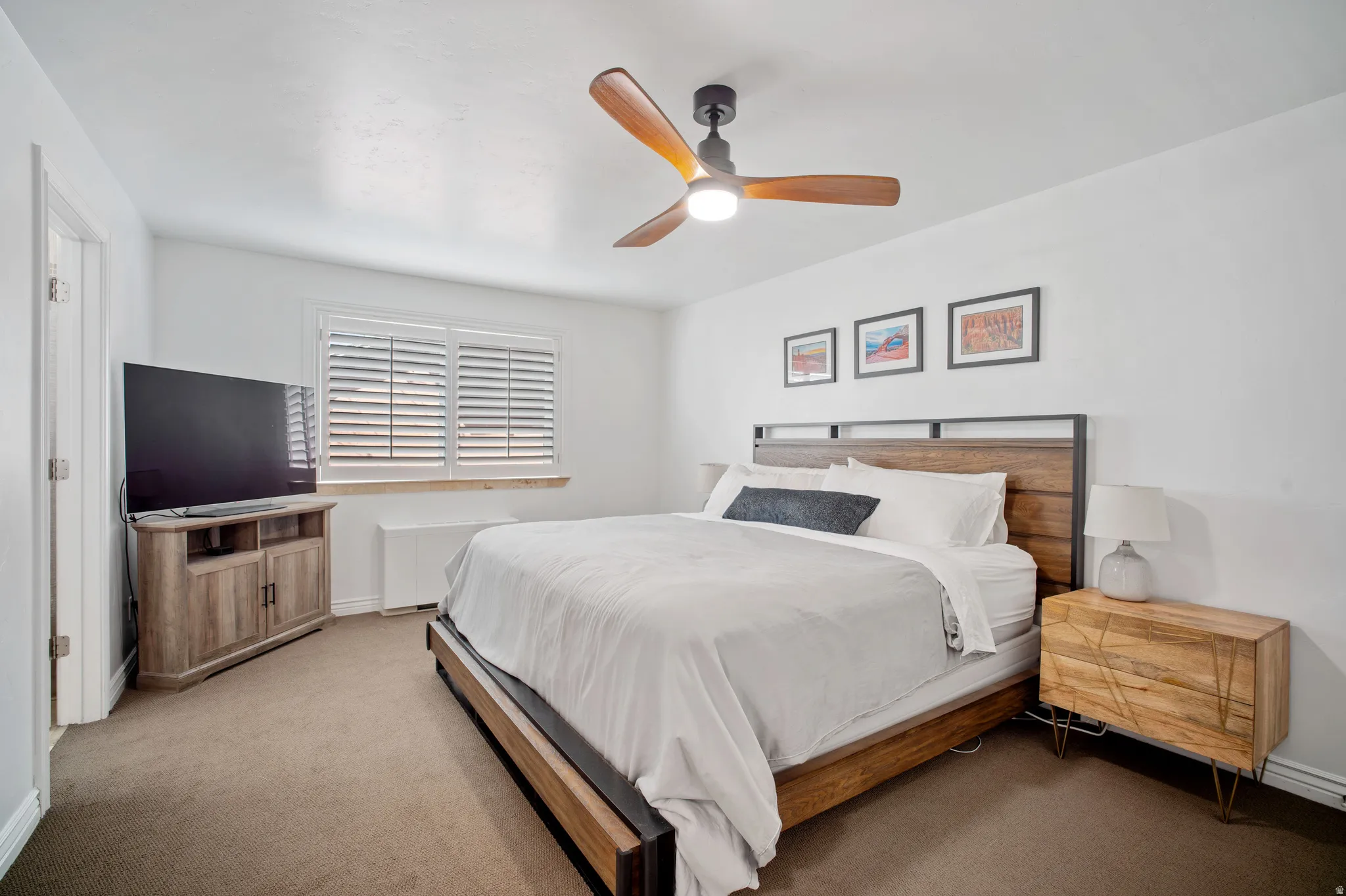 Carpeted bedroom with ceiling fan and baseboards