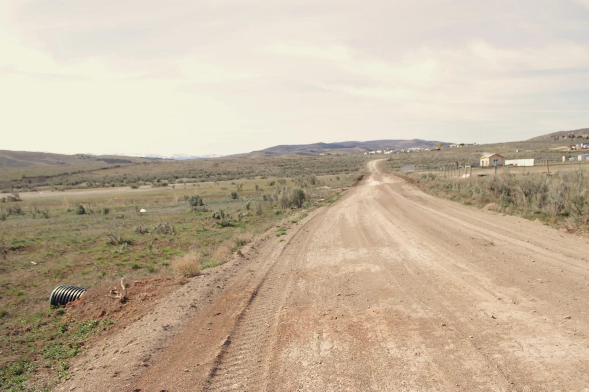 View of dirt / gravel road with a rural view and a mountain view