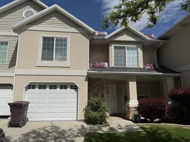 Traditional-style house featuring a garage, stone siding, stucco siding, concrete driveway, and covered porch