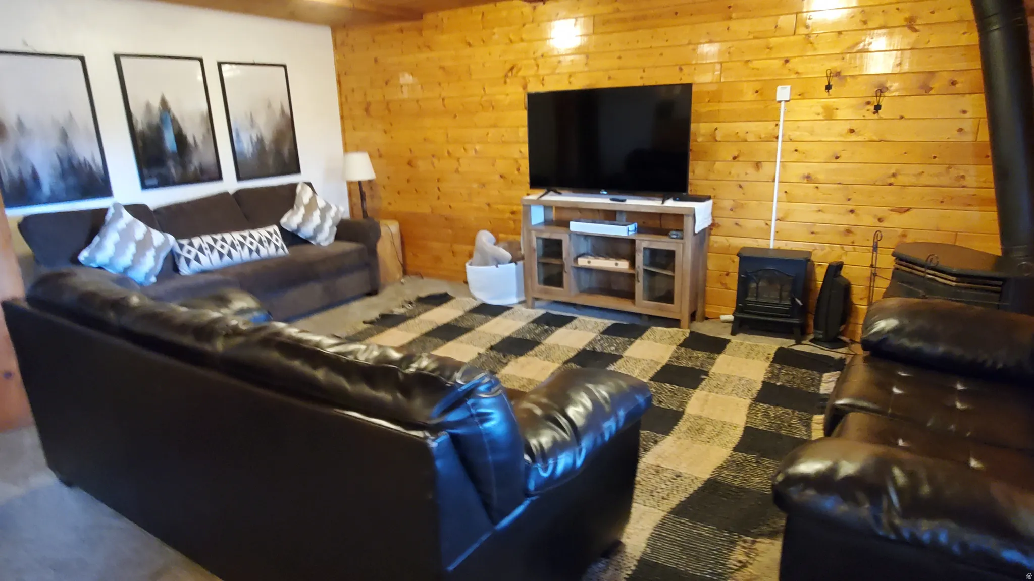 Living room with wooden walls and a wood stove