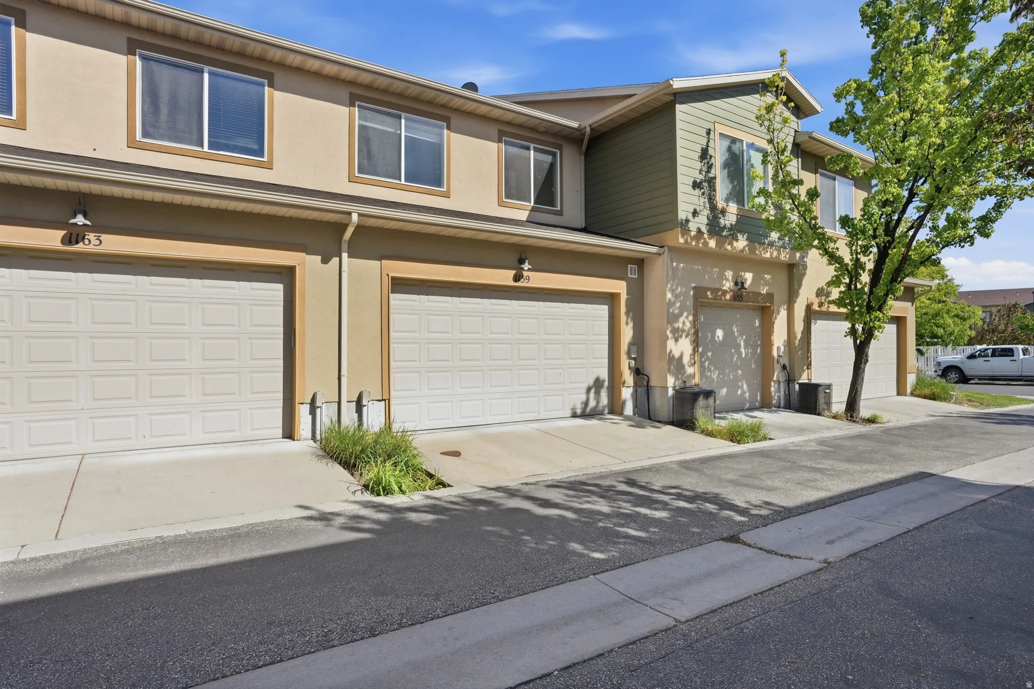 Traditional home featuring an attached garage, stucco siding, and concrete driveway