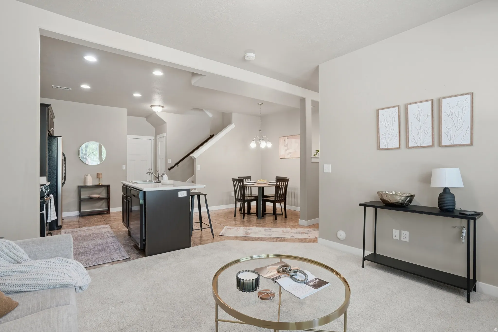 Living area with suspended lighting and light carpet