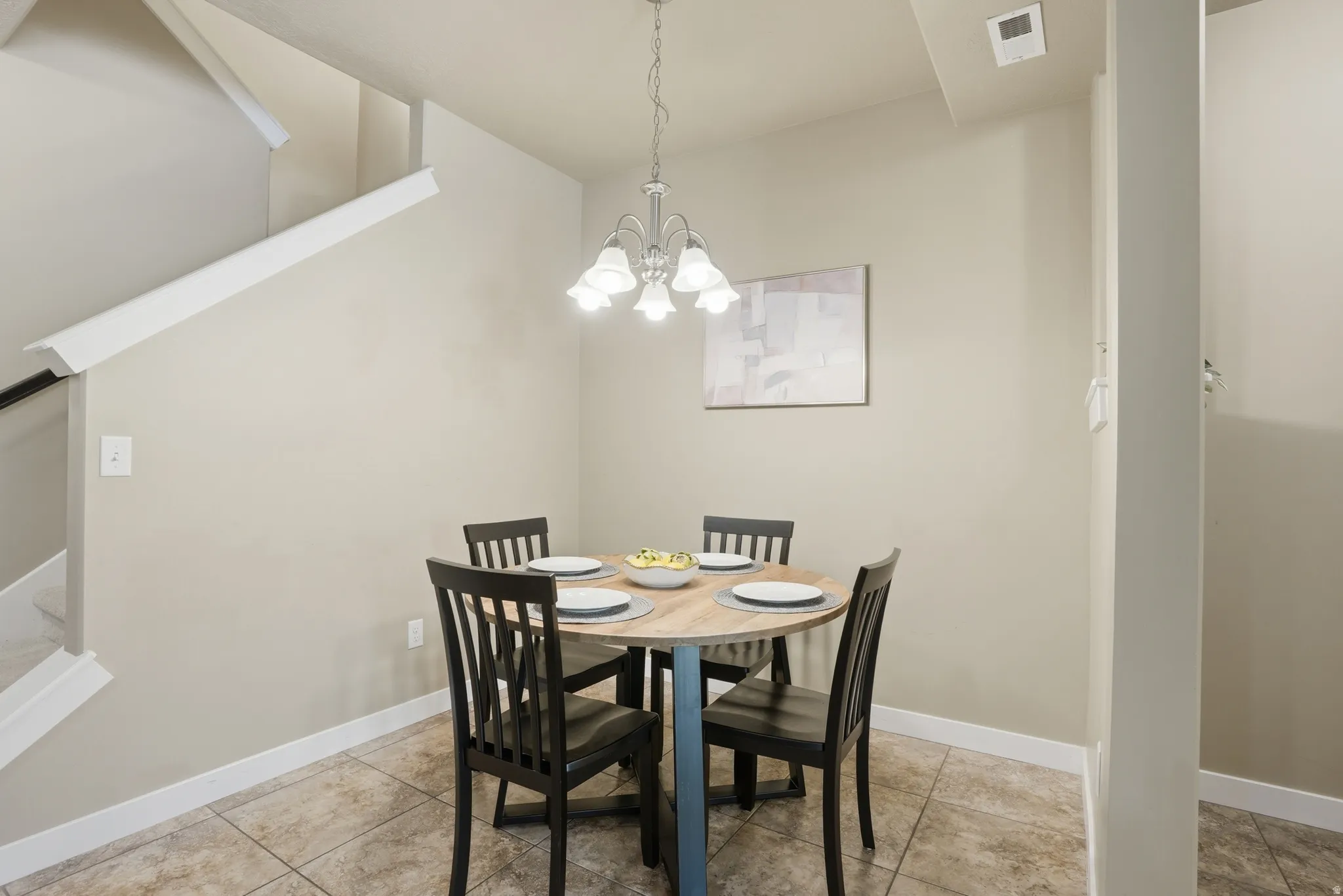 Dining area with stairs and a chandelier