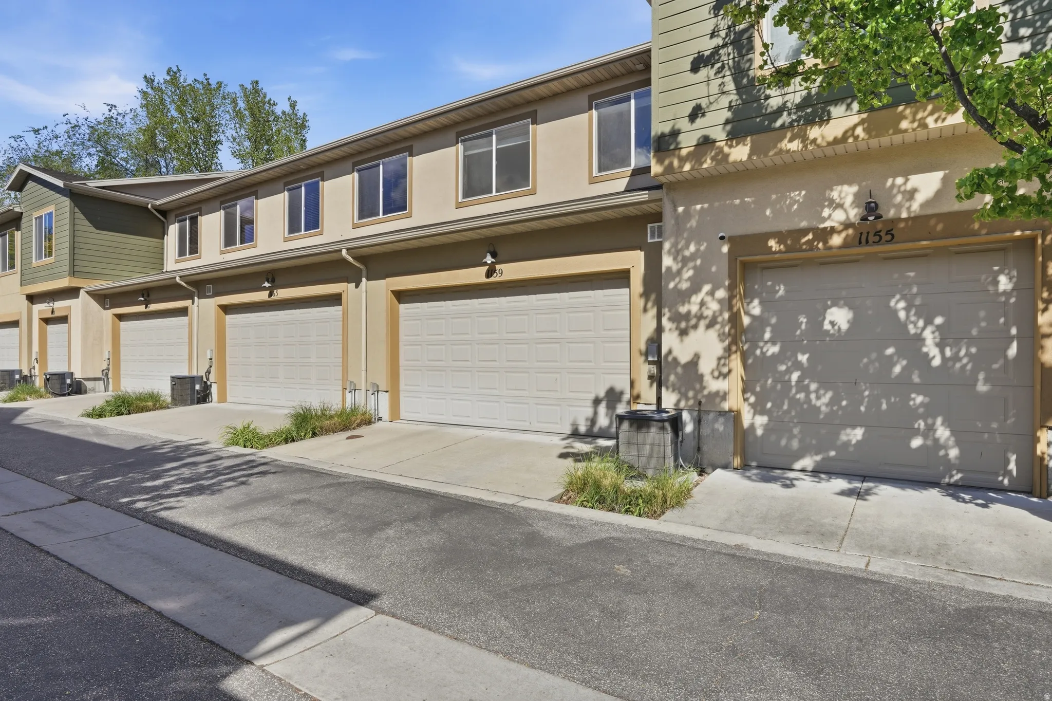 Traditional-style home featuring stucco siding, an attached garage, and driveway