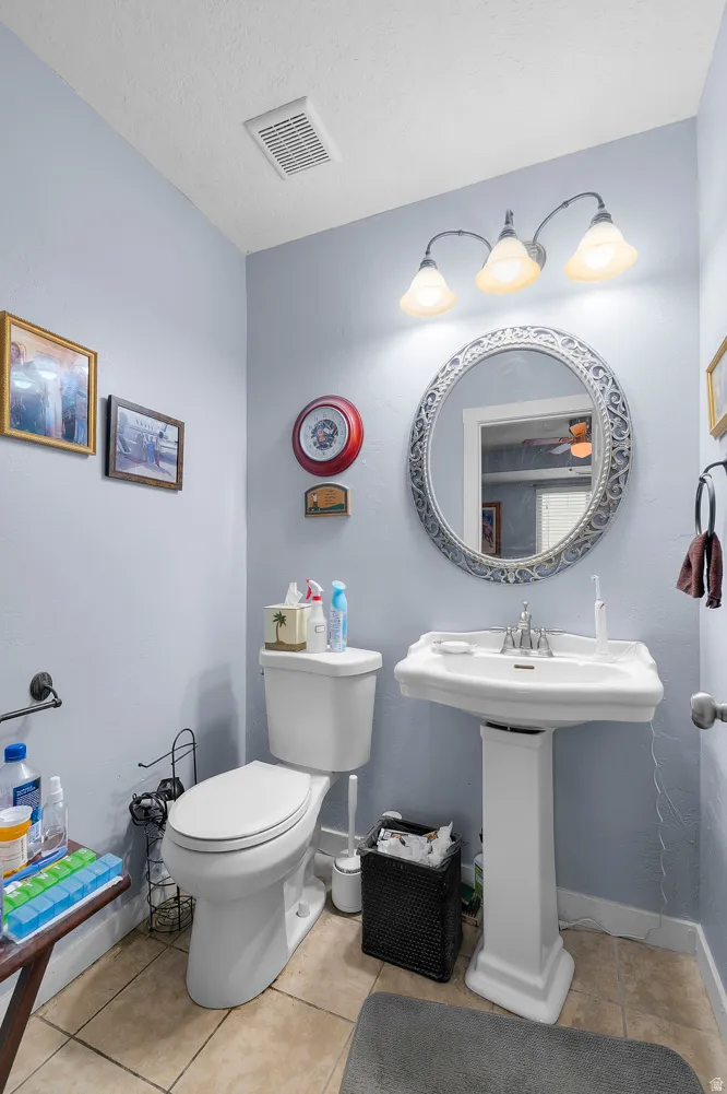 Bathroom with light tile patterned flooring and a textured ceiling