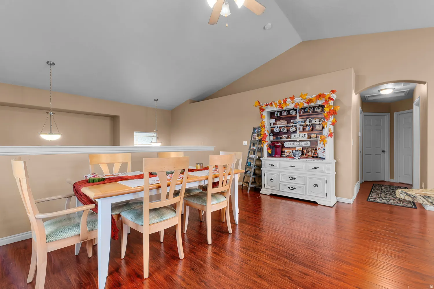 Dining area featuring lofted ceiling, ceiling fan, and dark wood-style floors