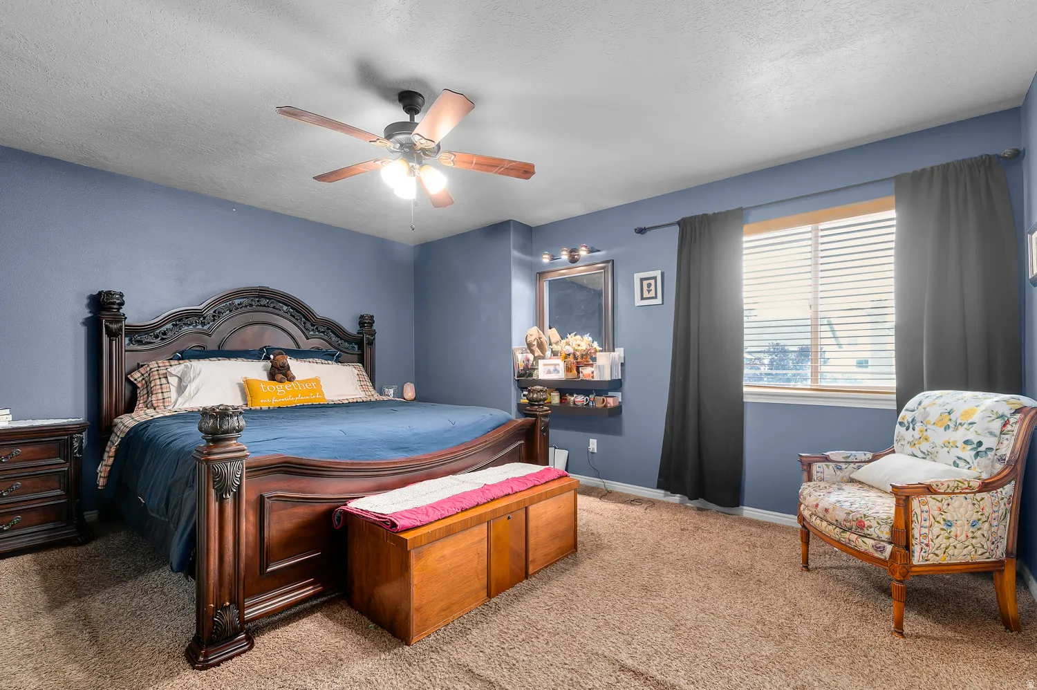 Bedroom featuring a textured ceiling, a ceiling fan, and carpet floors